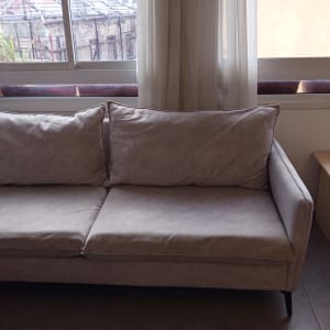 ספה אפורה ליד חלון עם שולחן קטן