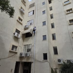 אדם מטפס על בניין גבוה עם ציוד בטיחות