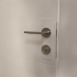 ידית דלת מתכתית עם מנעול על דלת לבנה