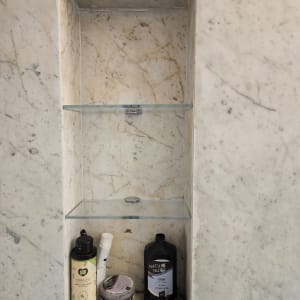 מדף זכוכית בתוך נישה בקיר שיש