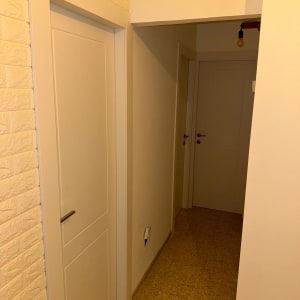 מסדרון עם דלתות לבנות וקיר לבנים