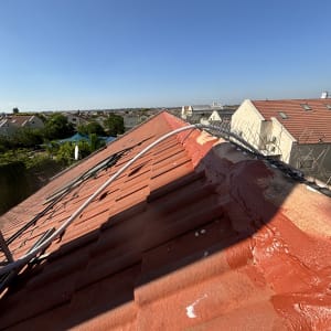 גג רעפים אדום עם צינור ומחסום מתכת