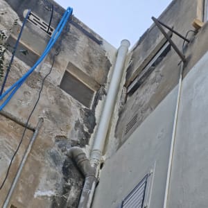 התקנת צנרת אינסטלציה וניקוז חיצונית בגובה על חזית בניין