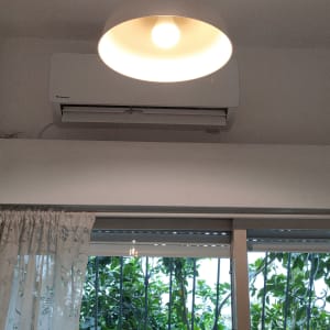 מזגן מותקן על קיר מעל חלון עם וילון