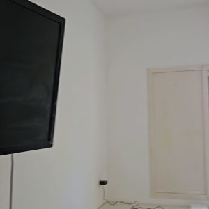 חדר עם קיר לבן, שולחן וטלוויזיה