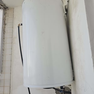 דוד שמש מותקן על קיר עם צינורות חיבור