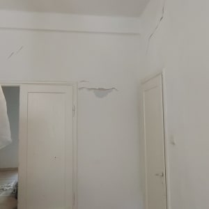 קירות עם סדקים ותיקונים נדרשים בחדר