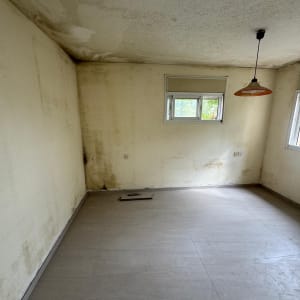 חדר עם קירות מתקלפים ותקרה מוכתמת