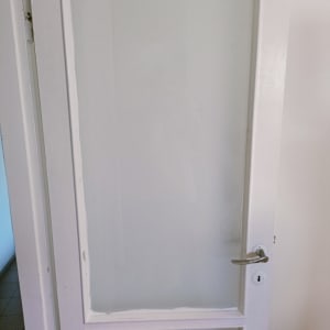 דלת עם זכוכית חלבית ומסגרת לבנה