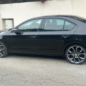 רכב שחור חונה על הכביש עם חישוקי גלגלים מעוצבים