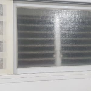 חלון זכוכית עם תריסים מאחוריו