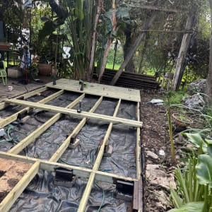 בניית דק עץ בגינה עם צמחייה מסביב