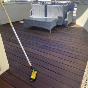 מגב צהוב על רצפת עץ במרפסת