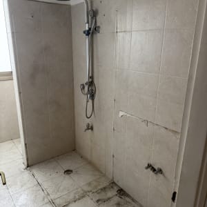 חדר מקלחת עם אריחים ומקלחת מותקנת