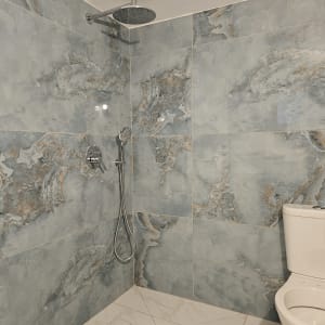 מקלחת חדשה עם אריחים אפורים וברז גשם