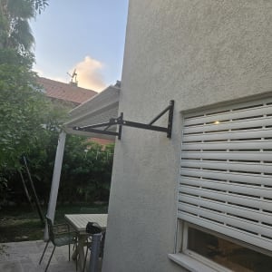 קיר חיצוני עם מתקן תלייה ותריסים סגורים