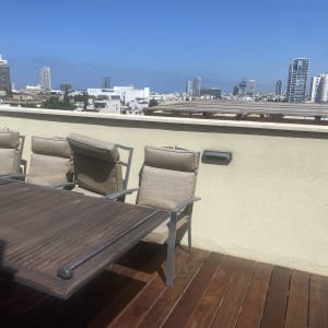 שולחן עץ וכיסאות על רצפת דק במרפסת