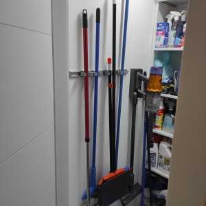 מגוון מטאטאים ומגב תלויים על הקיר