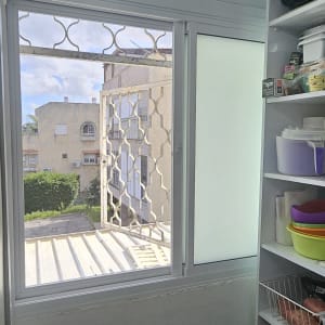 חלון אלומיניום עם סורגים ומדפים בצד