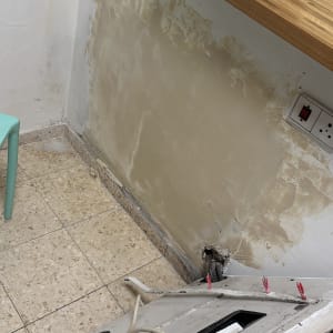 קיר עם תיקוני טיח, כבלים חשמליים, שקע חשמל