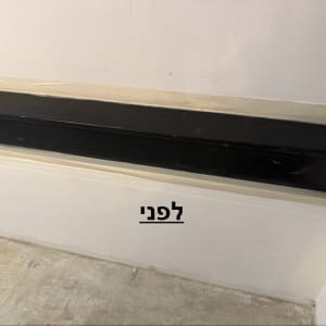 קיר עם פס שחור ולפניו רצפה