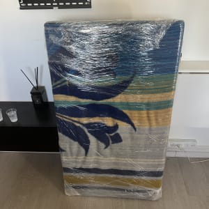 רהיט עטוף בניילון ליד קיר עם מתקן תלייה