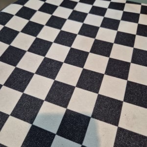 בד משובץ שחור ולבן על כיסא