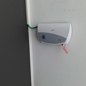 מכשיר חשמלי עם כבל ירוק על קיר