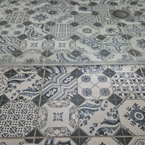 רצפת מקלחת עם אריחים מעוצבים ודלת זכוכית