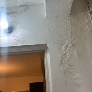 מנורה דולקת על קיר עם סימני רטיבות