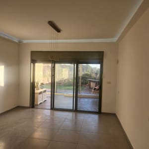 חדר ריק עם קירות לבנים ותאורה טבעית