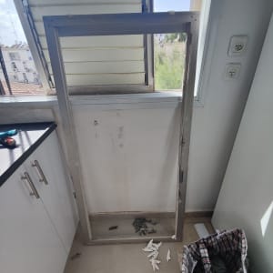 תריסים פתוחים עם מסגרת חלון מונחת על הרצפה