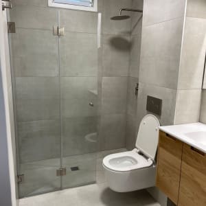 חדר אמבטיה נקי עם מקלחון ושירותים