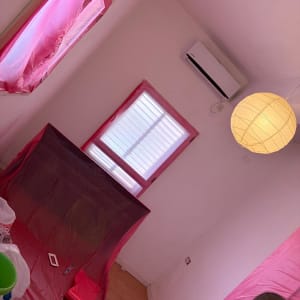חדר עם קירות צבועים, חלונות מכוסים בניילון, כלי עבודה לצביעה