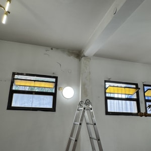 סולם ליד קיר עם סימני תיקון וצביעה