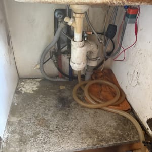 כיור עם צנרת וכלים מתחת לכיור