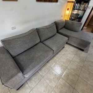 ספה אפורה בחדר מגורים עם רצפת קרמיקה