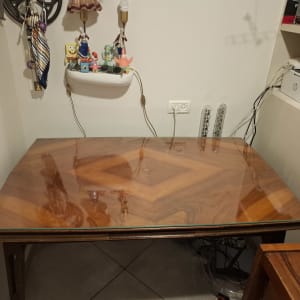 שולחן עץ עם משטח זכוכית שקוף מעליו