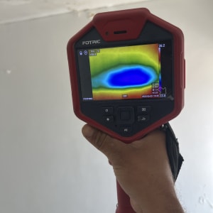 מד חום תרמי מציג אזור כחול על קיר לבן