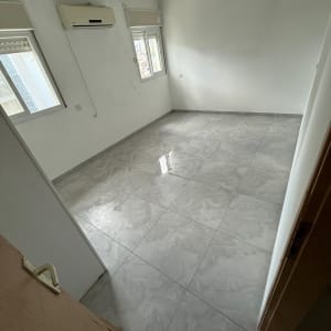 חדר ריק עם רצפת קרמיקה חדשה וקירות צבועים