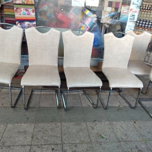 שישה כיסאות מרופדים עם רגלי מתכת על מדרכה