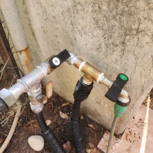 צינורות ומחברים מתכתיים עם ברזים על קיר בטון