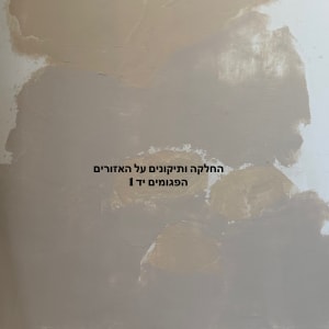 קיר עם תיקוני טיח ושקיות חומרי בניין
