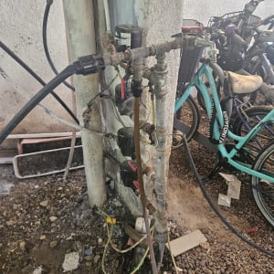 צנרת מים עם ברזים ודליפות ליד אופניים