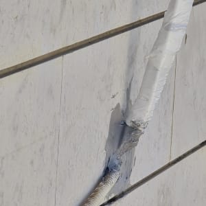 צינור מחובר לקיר עם חומר איטום