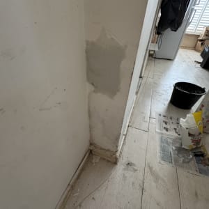 קיר עם תיקוני צבע וכלי עבודה על הרצפה