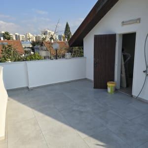 מרפסת עם ריצוף חדש ודלי צבע