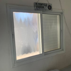 חלון זכוכית עם שלט בלומפילד סטדיום תלוי מעליו