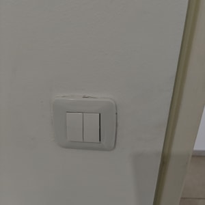 מתג חשמל כפול על קיר לבן