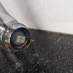 ברז שבור על משטח שיש כהה